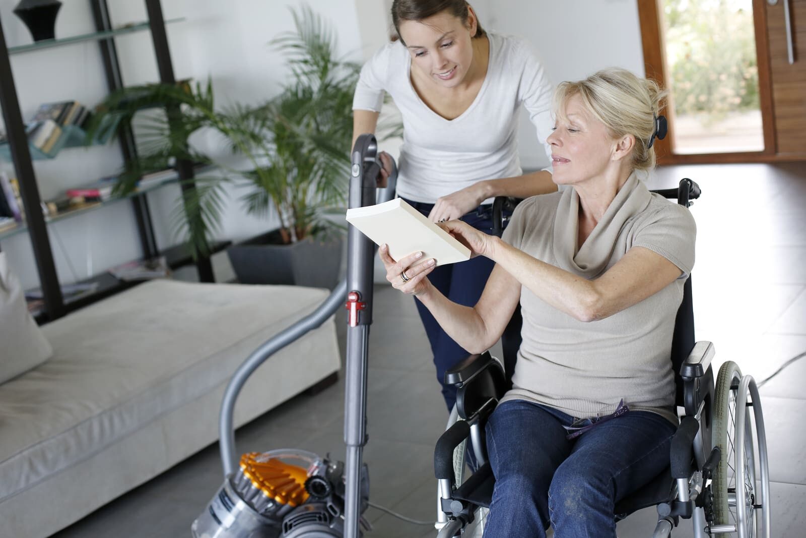 Aide à domicile assistant une personne en fauteuil roulant